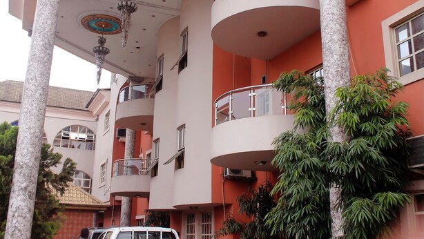 A multi-story building with balconies, large windows, and a central atrium with a chandelier. - Paloma Hotels (Port Harcourt)