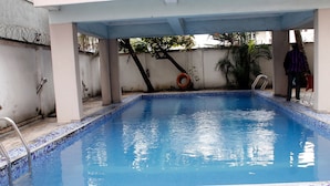 A swimming pool with tiled edges and a metal ladder. - Paloma Hotels (Port Harcourt)