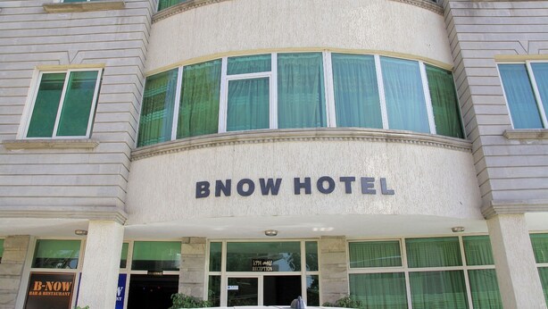 Exterior do Hotel Bnow, com área de recepção e placa indicando B-Now Bar & Restaurante.