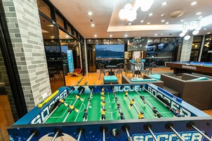 A foosball table in a well-lit indoor space with a view of the mountains through large windows.