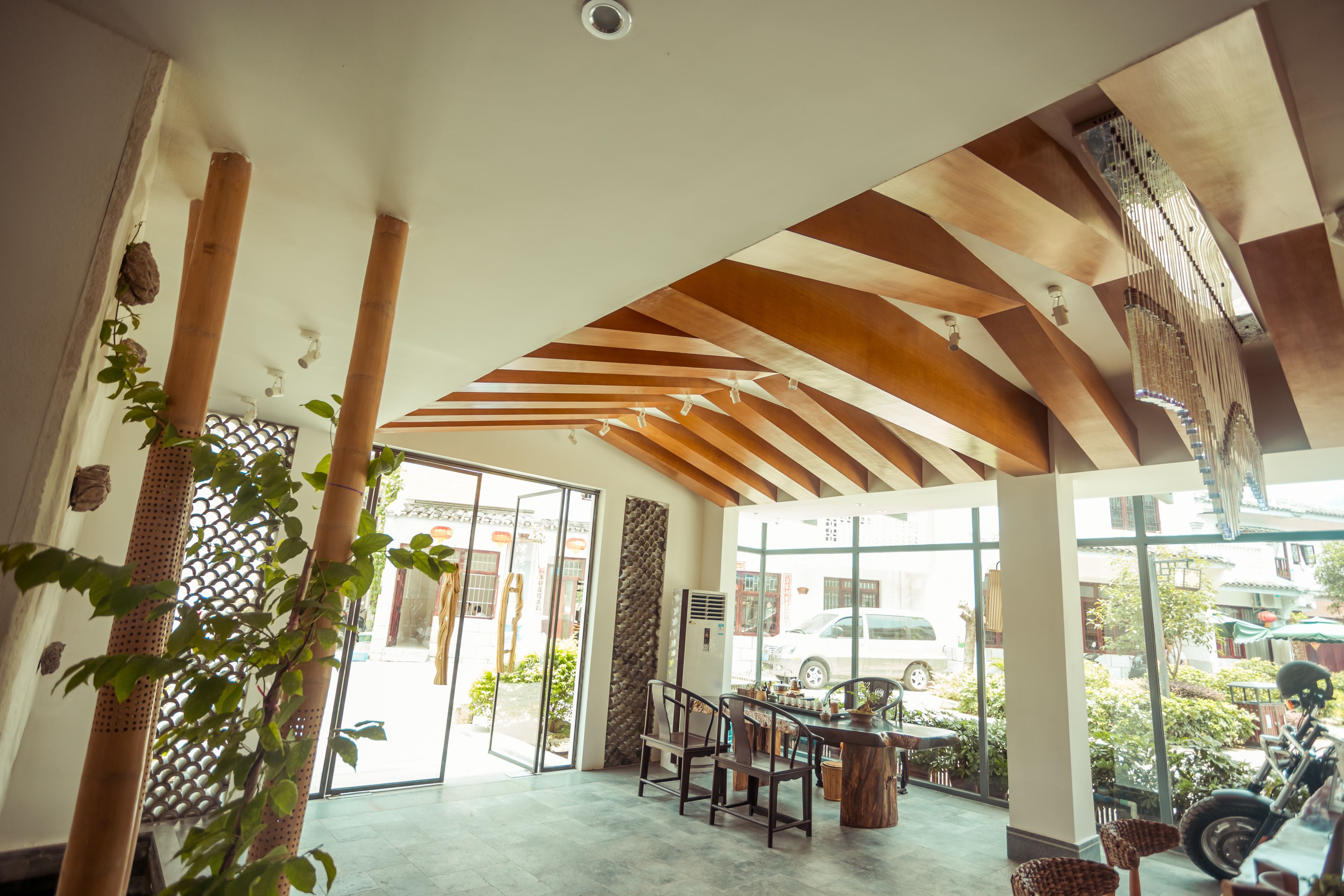 Un interior espacioso con techo alto, ventanas grandes y un comedor con sillas y una mesa.