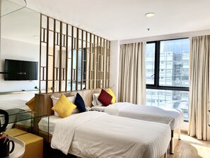 A hotel room with two beds, a TV, a desk, and a large window with a city view. - IW Hotel (Kowloon)