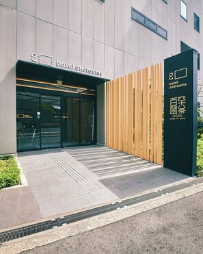 A modern hotel entrance with a sign reading "hotel androoms" and a wooden fence on the right. - hotel androoms Shin-Osaka (Osaka)