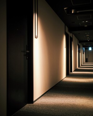 A long, narrow hallway with a carpeted floor and walls on both sides. - hotel androoms Shin-Osaka (Osaka)