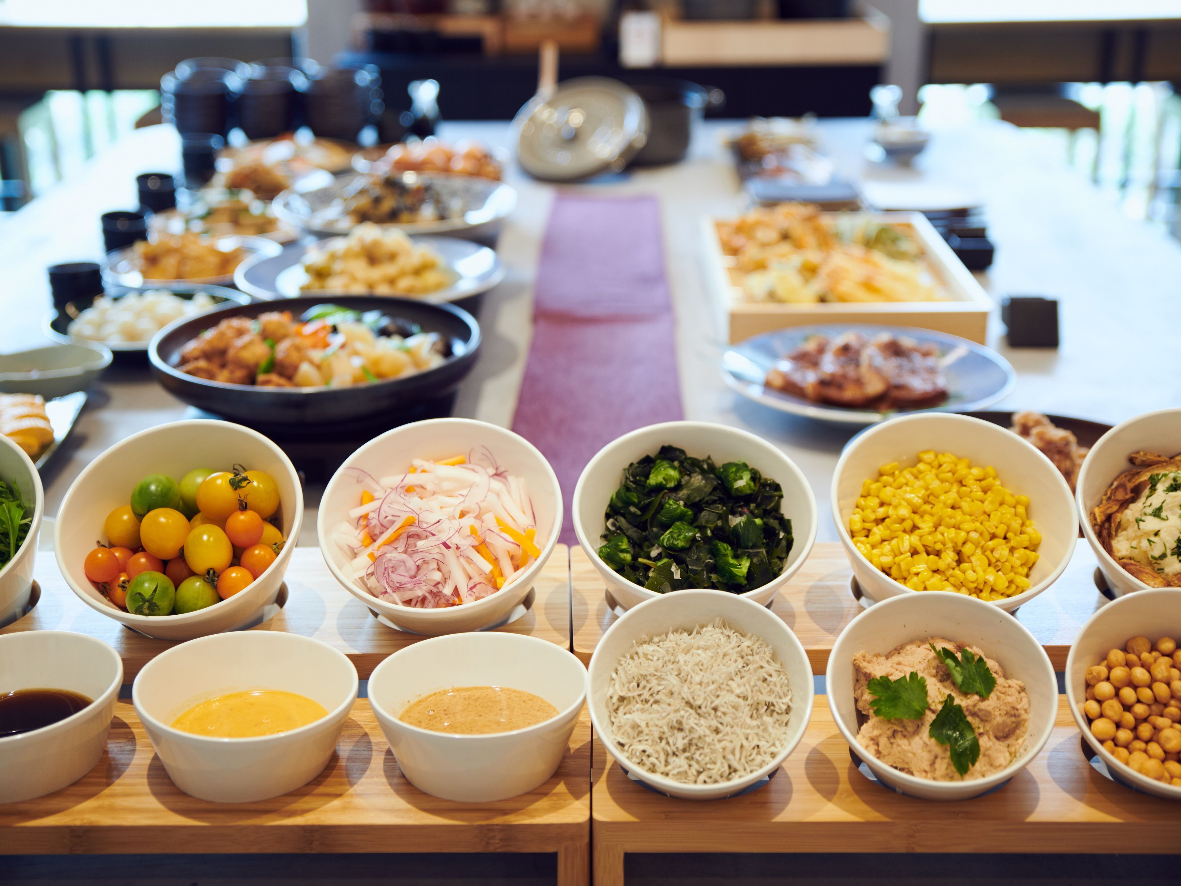 A buffet table with various dishes and side dishes.