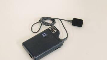 Une batterie externe portable noire, livrée avec un câble USB et un connecteur USB.