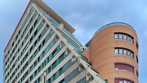 A modern building with a corner intersection of a rectangular and a cylindrical structure.