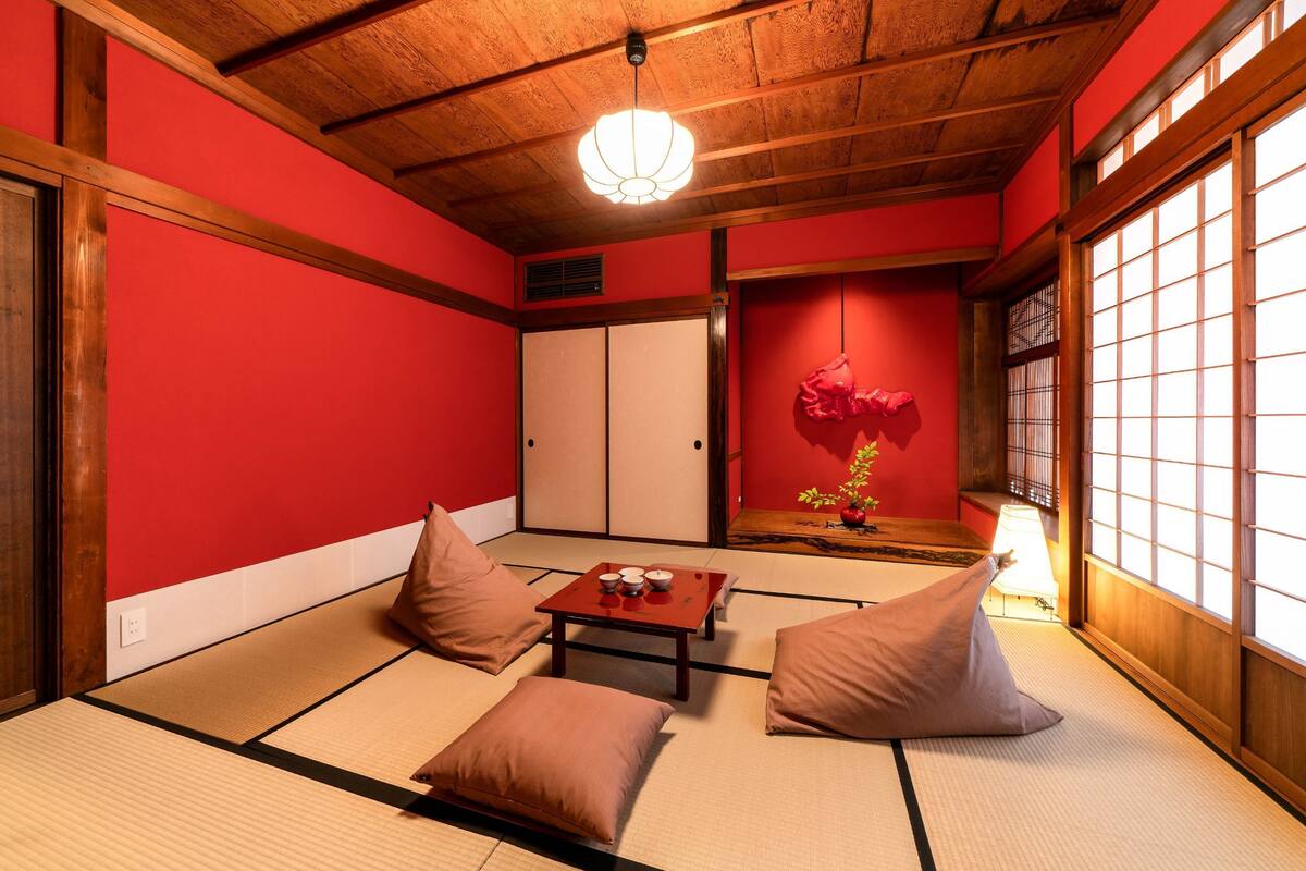 A traditional Japanese room with tatami flooring, a low table with a tea set, and a shoji screen door.