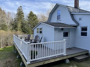 Une maison à deux étages avec une terrasse couverte et un petit porche.