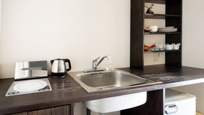 A modern kitchen with a stainless steel sink, a kettle, a scale, and a shelf with dishes and cups. - Higashiyama Aritsuki (Kanazawa)