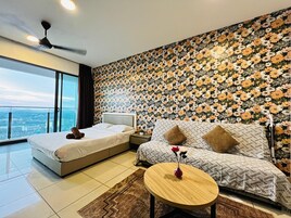Habitación de hotel con una cama grande, un sofá, una mesita y vistas a la ciudad.