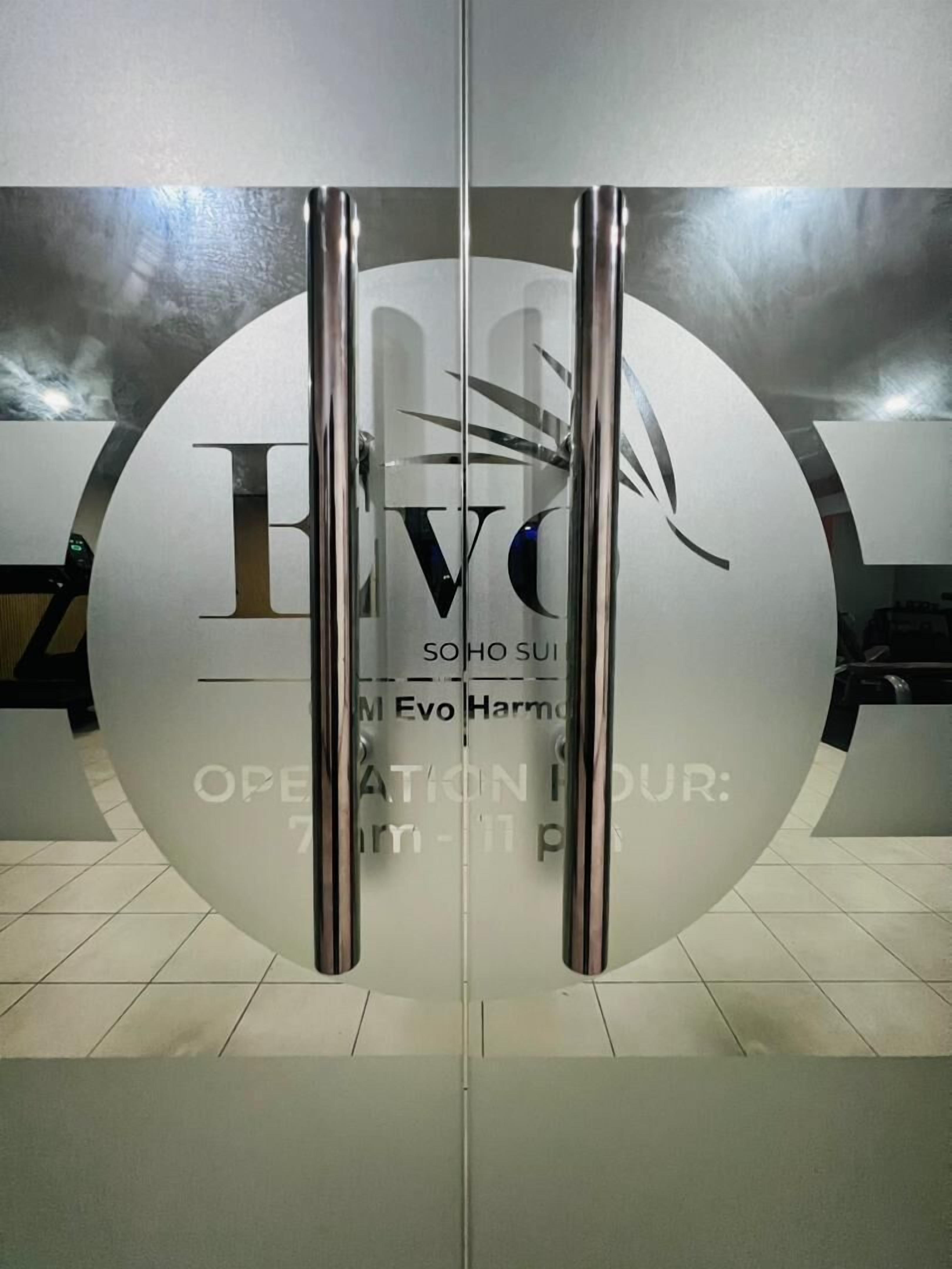 A modern glass door with the logo 'EVO' and the text 'SOHO SUI' and 'M Evo Harmd' on it.