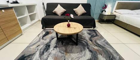 A modern living room with a sofa, a coffee table, a TV, and a decorative wall piece.