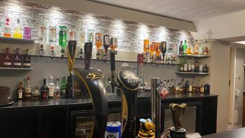 A bar area with multiple beer taps, a variety of liquor bottles, and a decorative honey dipper.
