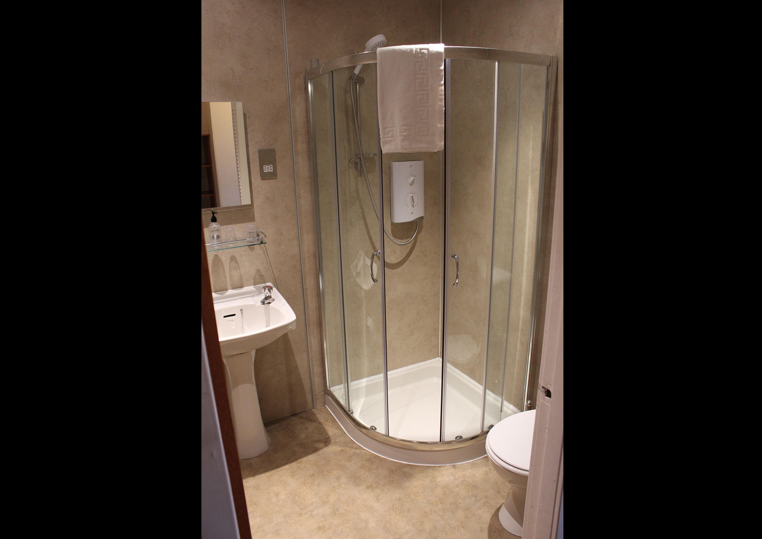Une salle de bain moderne avec une douche à parois de verre, un lavabo et des toilettes.