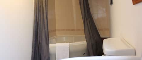 A bathroom with a bathtub, toilet, and sink.