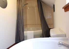 Un baño con bañera, inodoro y lavamanos.