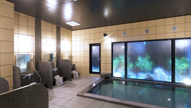 A spa area with a large indoor pool, seating, and a waterfall feature. - Hotel Route Inn Osaka Takaishi Hagoromo Ekimae (Takaishi)