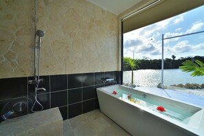 Une salle de bain moderne avec une baignoire, une douche et une vue sur un lac.