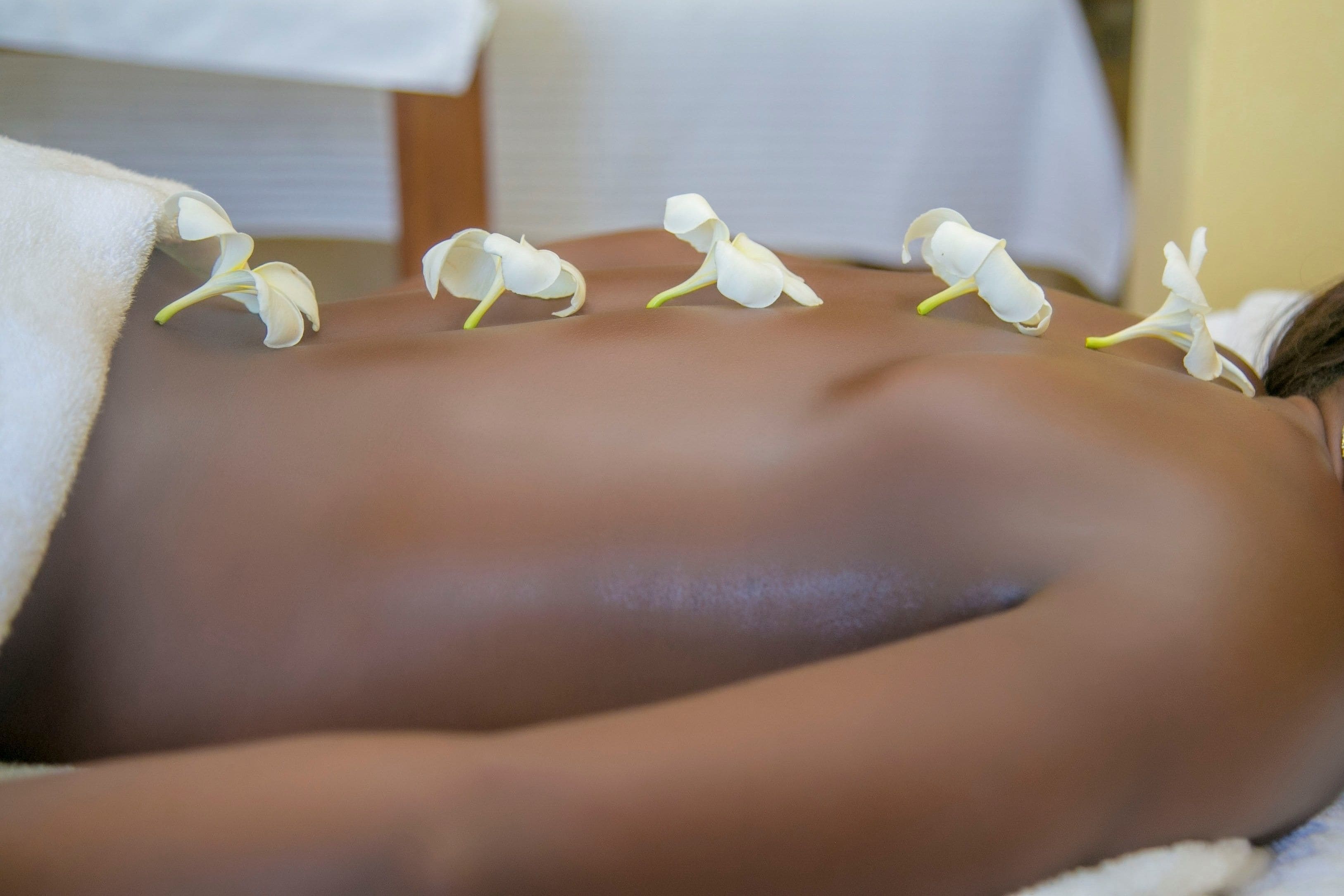 A person lying down with white flowers on their back.