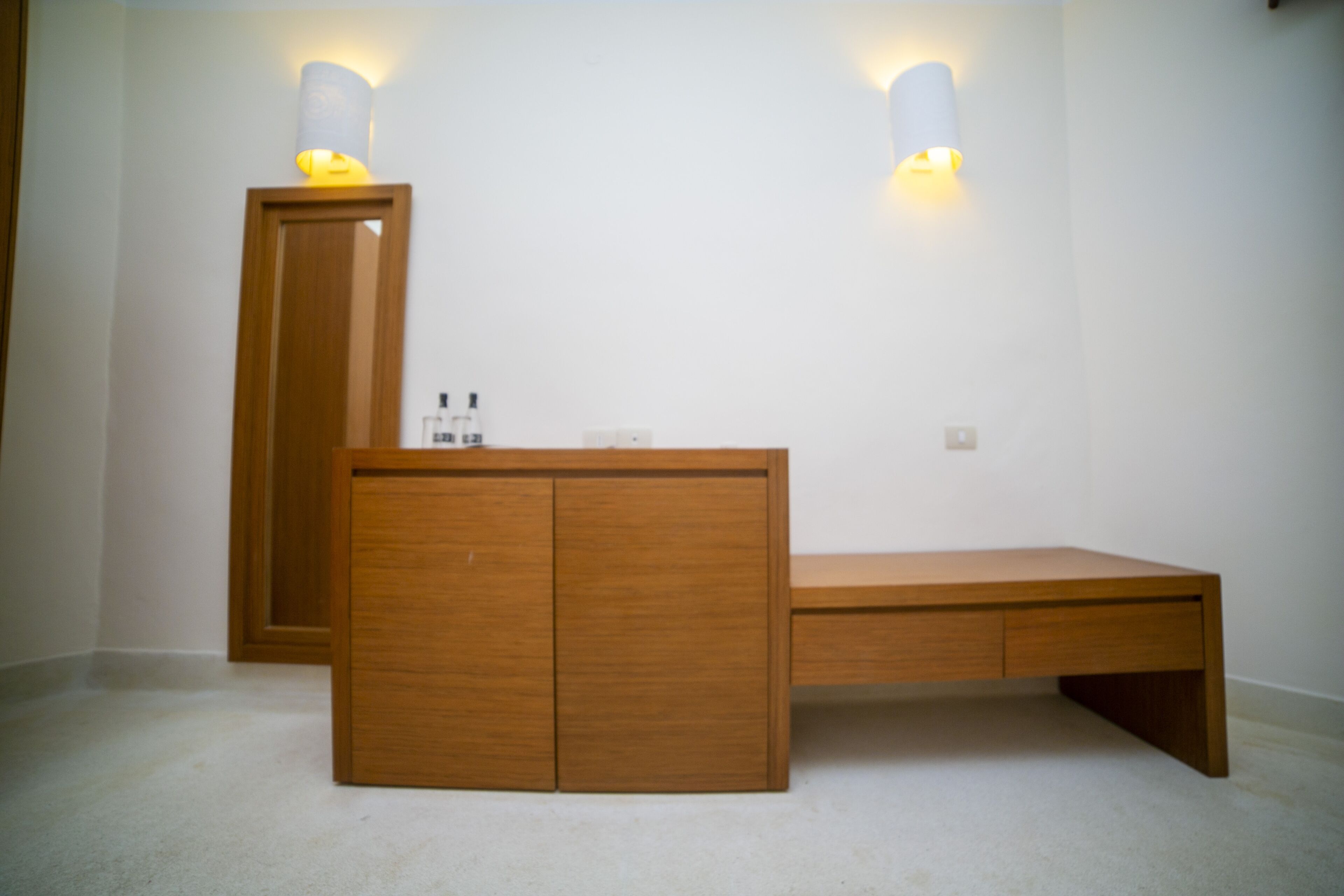 Ein Schlafzimmer mit einem Holzbett, einem Nachttisch und zwei Wandlampen.