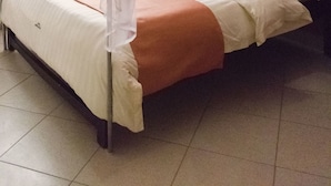 Un lit à baldaquin, avec des oreillers et une table de chevet.
