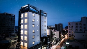 A modern hotel with multiple floors, large windows, and a prominent 'RUN HOTEL' sign. - Run Hotel (Seogwipo)