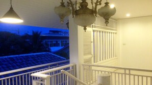A balcony with white railings and a hanging light fixture. - Villa Sittiprapa (Nakhon Ratchasima)