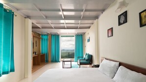 A hotel room with a large bed, a desk, a chair, and a view of the outdoors. - Nest and Hives Mukteshwar (Dhari)