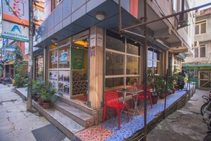 Un restaurante con terraza, plantas en macetas y un letrero visible que dice 'ANNAPURNA'.