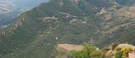 A mountainous landscape with a prominent peak and surrounding greenery.