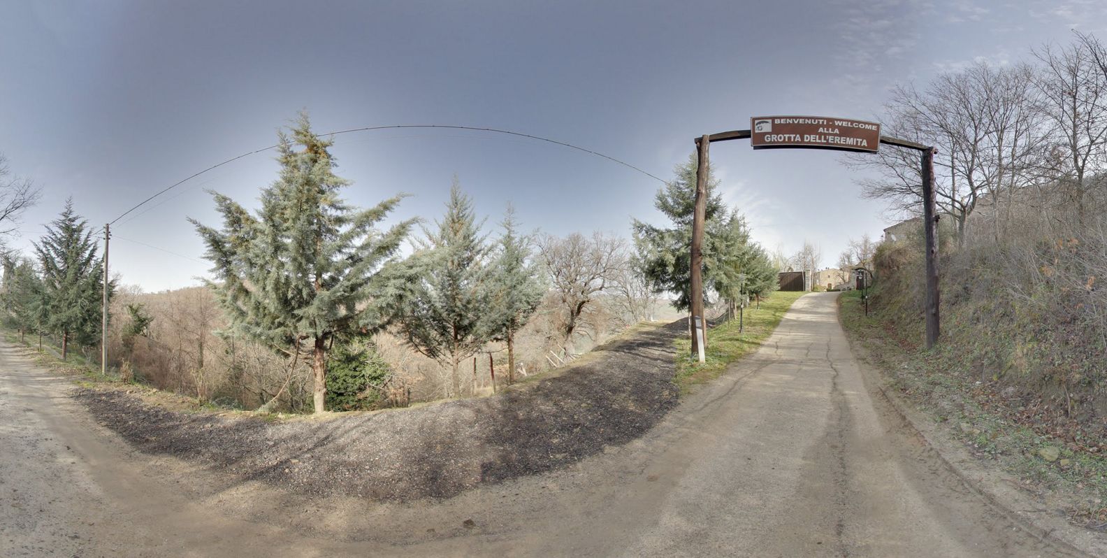 Un camino rural con un cartel que dice "BENVENUTI - WELCOME ALLWELOME Grotta DELL'EMITTA".