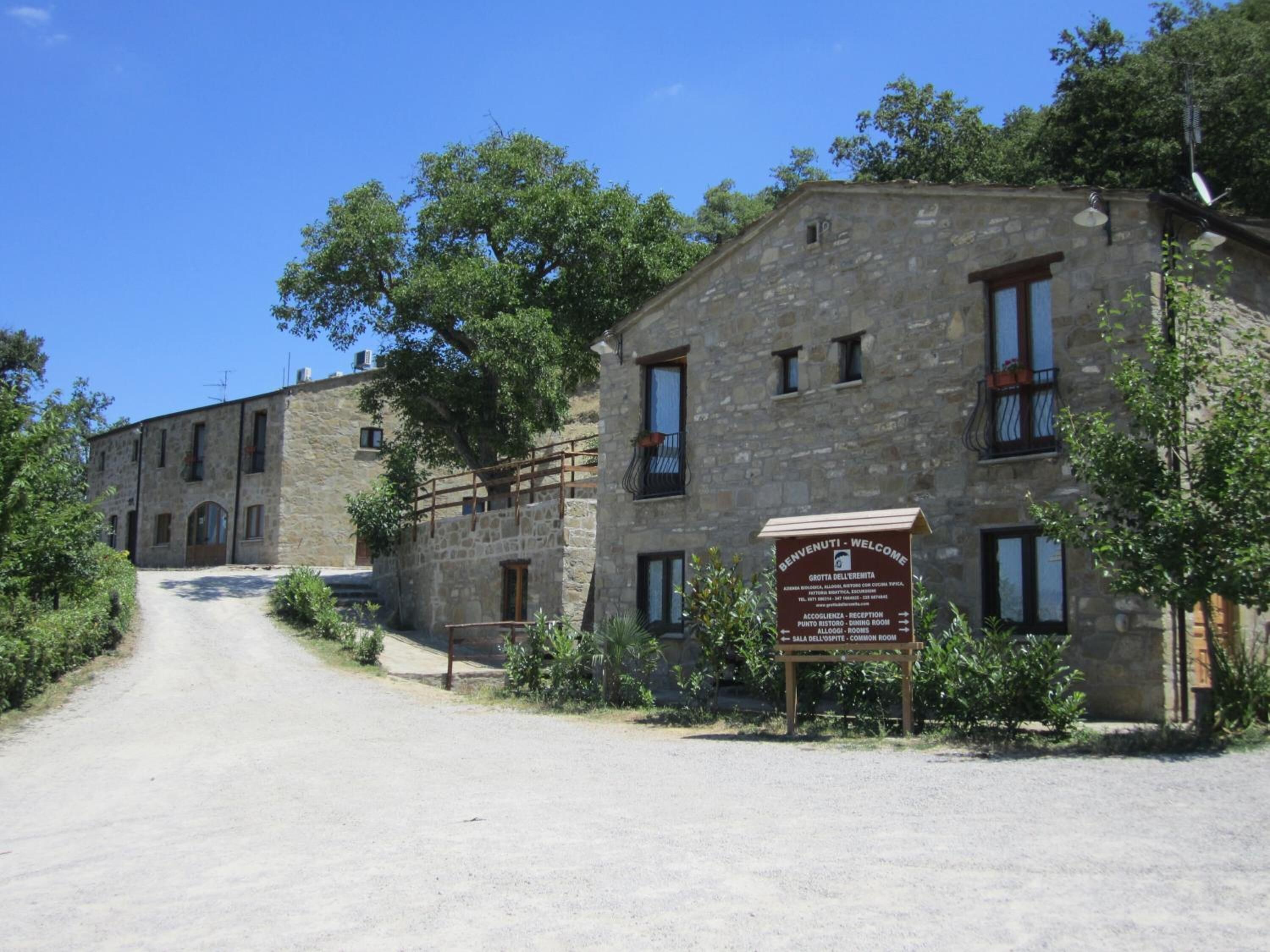 A stone building with a sign indicating a reception, dining room, and common room.