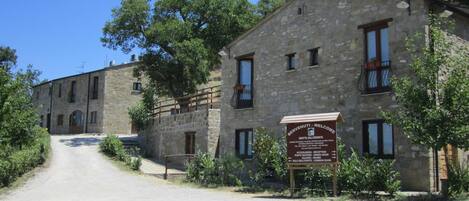 A stone building with a sign indicating a reception, dining room, and common room.