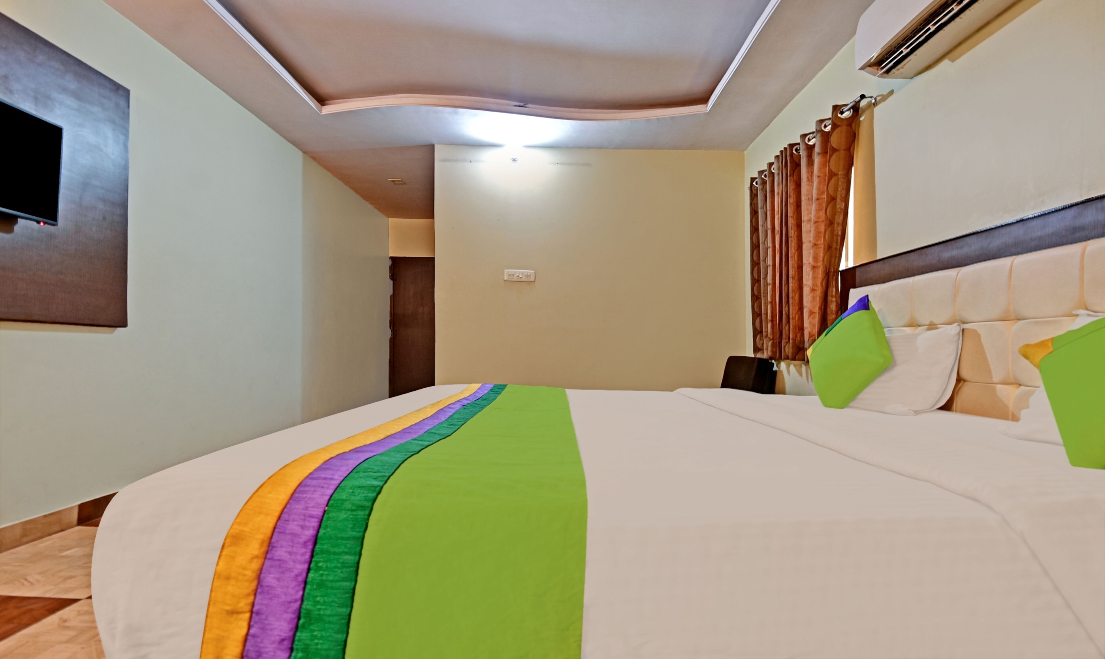 A hotel room with a large bed, a headboard, and a nightstand.