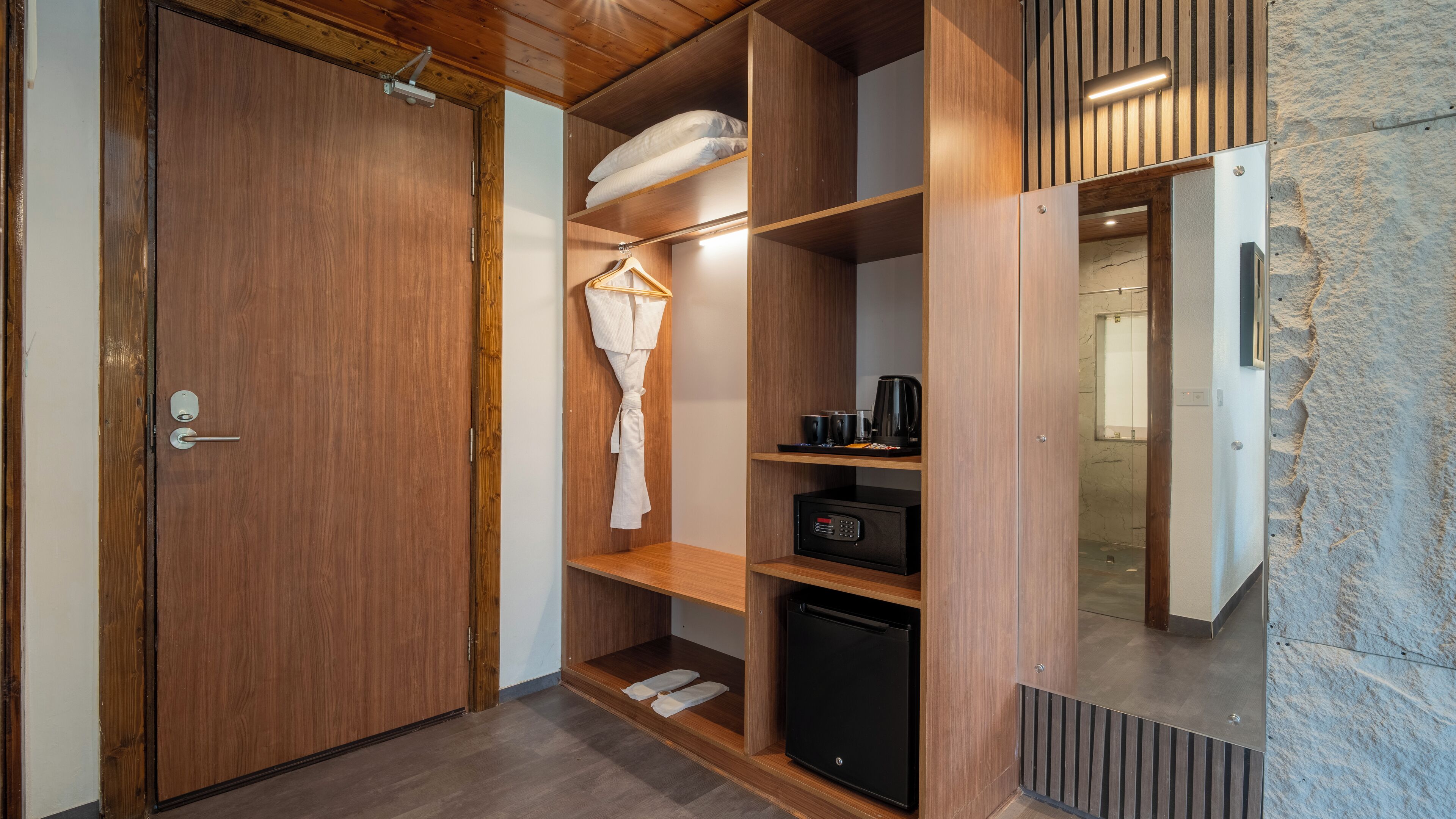 Een moderne badkamer met een houten wastafelmeubel, een zwarte koffiezetapparaat en een handdoekrek.