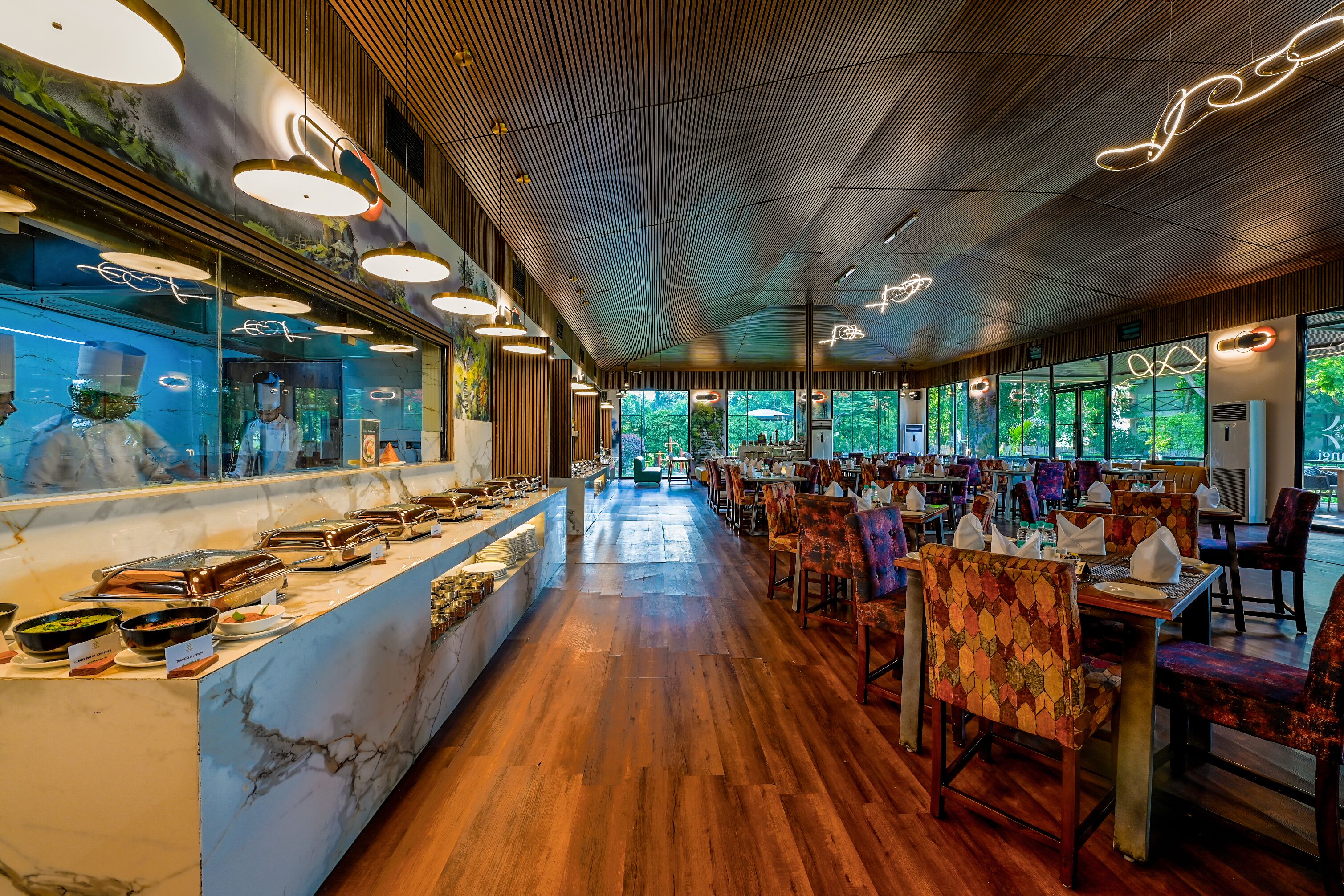 Un restaurant doté d’un long comptoir, d’un plancher en bois et d’un éclairage moderne.