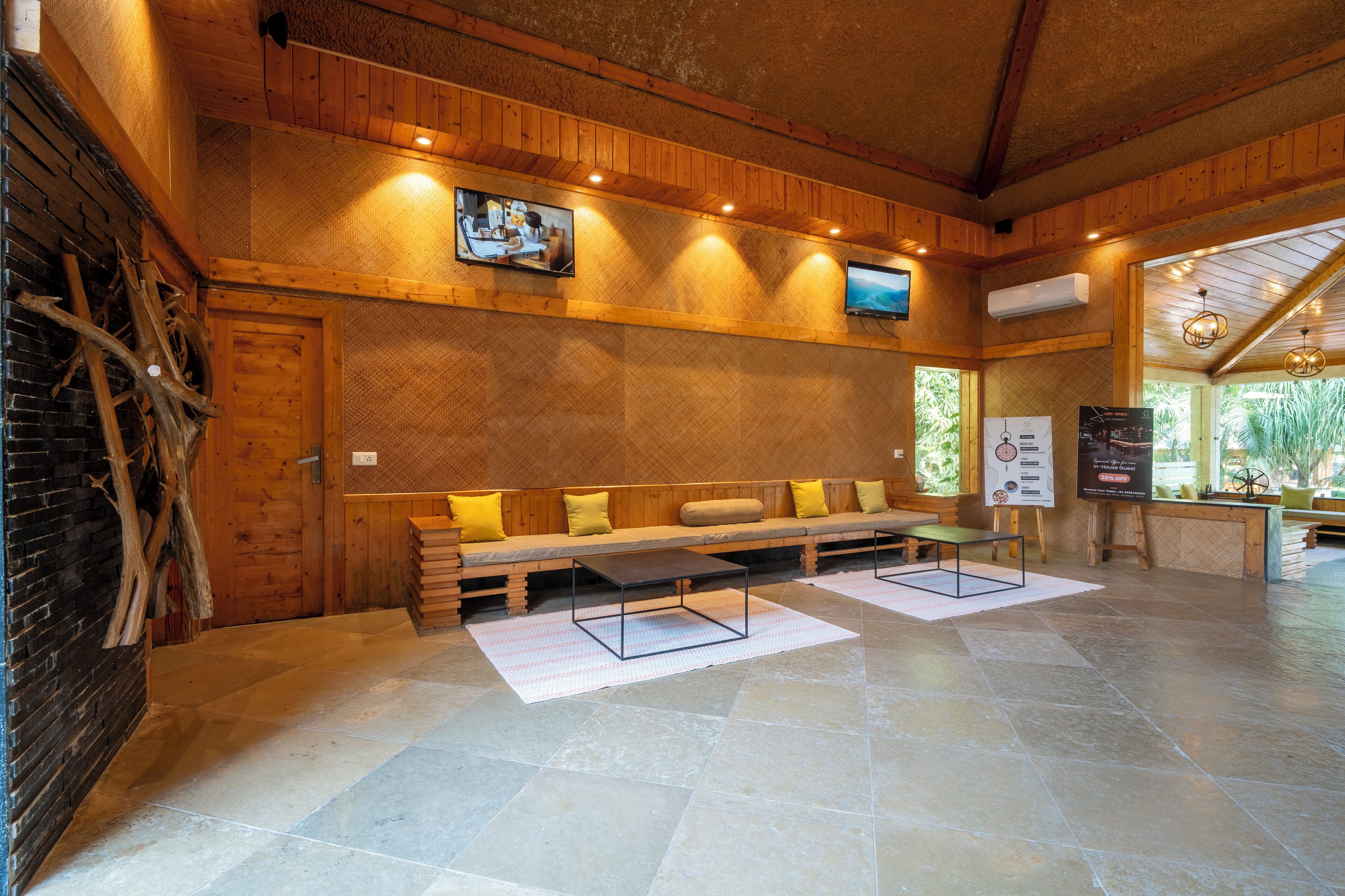 Un interior de madera con un banco, un televisor y una chimenea.