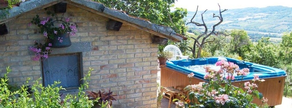 Ein Steinhaus mit einem Fenster, einer Whirlpool-Badewanne und Blick auf die Landschaft.