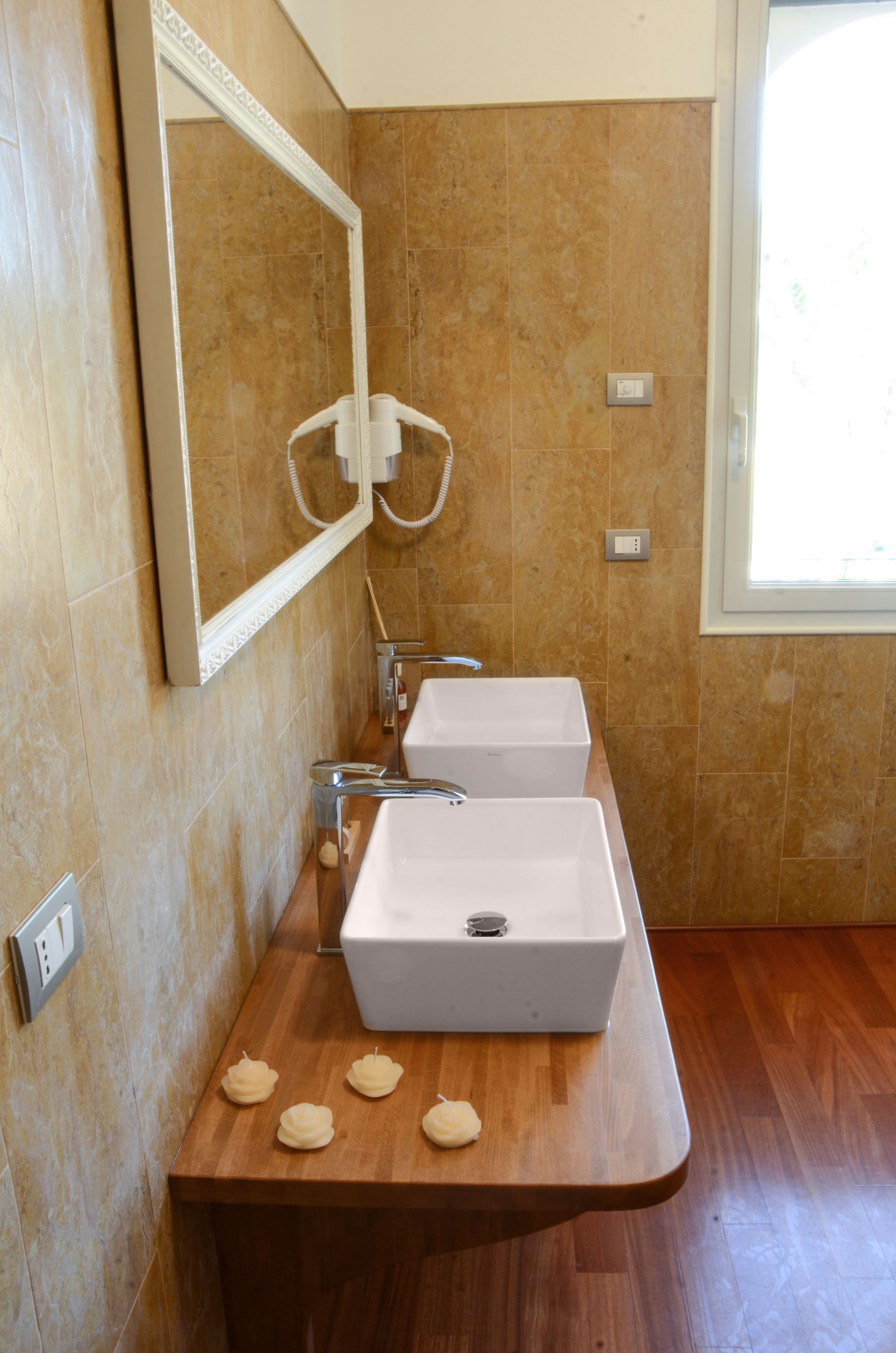 A bathroom with two sinks, a mirror, and a wooden vanity.