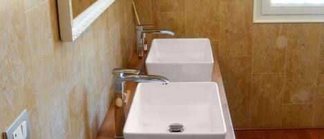 A bathroom with two sinks, a mirror, and a wooden vanity.