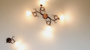 Un lit avec un matelas matelassé, deux oreillers et un appliques mural décoratif.