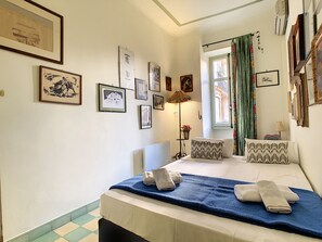 A bedroom with a bed, a nightstand, a lamp, and a window with curtains. - N&J - SIXTIES - Central - Very close sea - Retro (Niza)