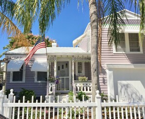 Classic two-story house with a white picket fence, porch, and garden.