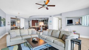 Ein modernes Wohnzimmer mit einer Couch, einem Couchtisch und einem Deckenventilator.