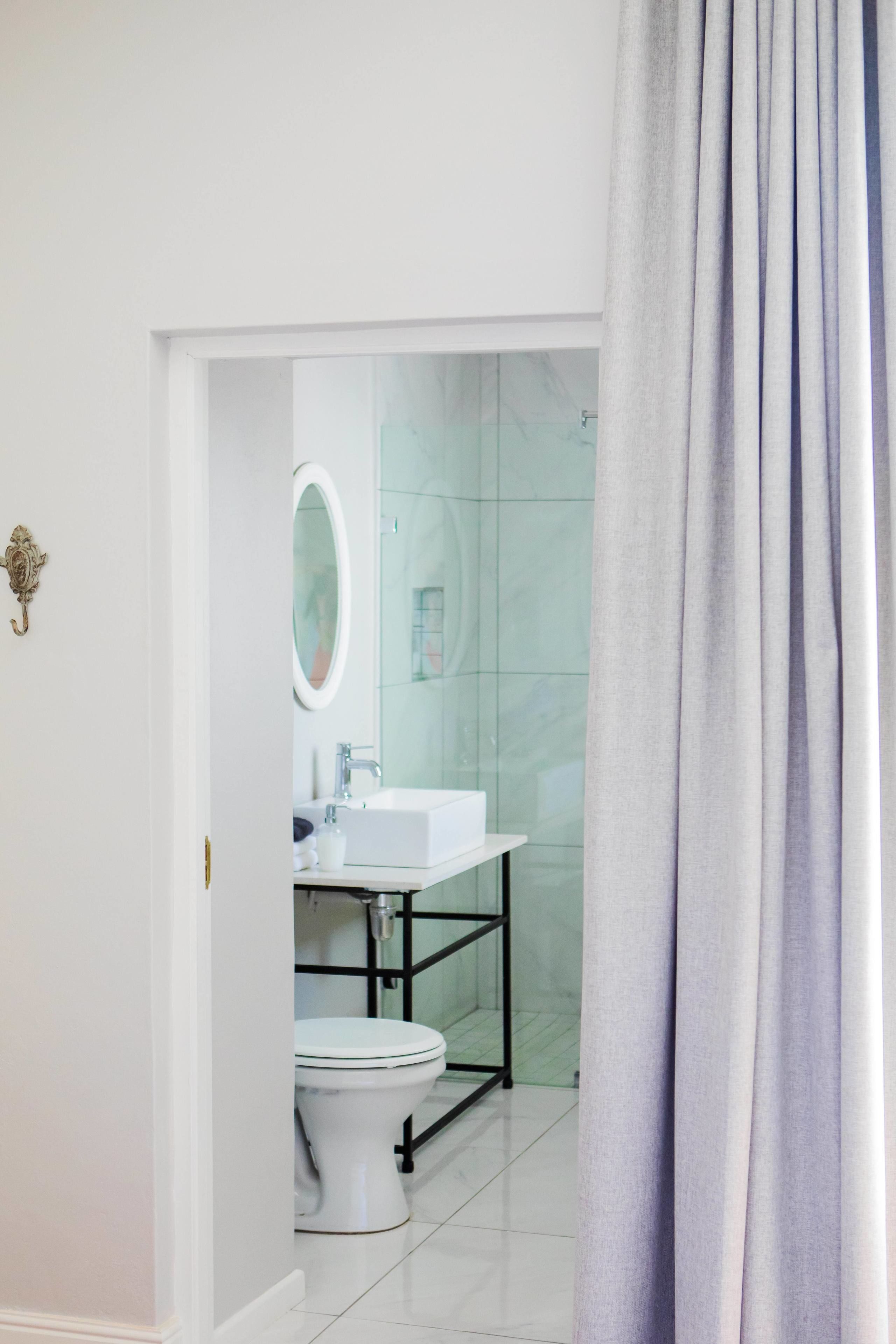 A bathroom with a white toilet, a white sink, and a mirror.