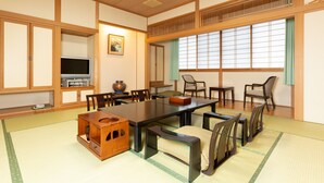 A traditional Japanese-style room with tatami flooring, a low table, and wooden furniture.