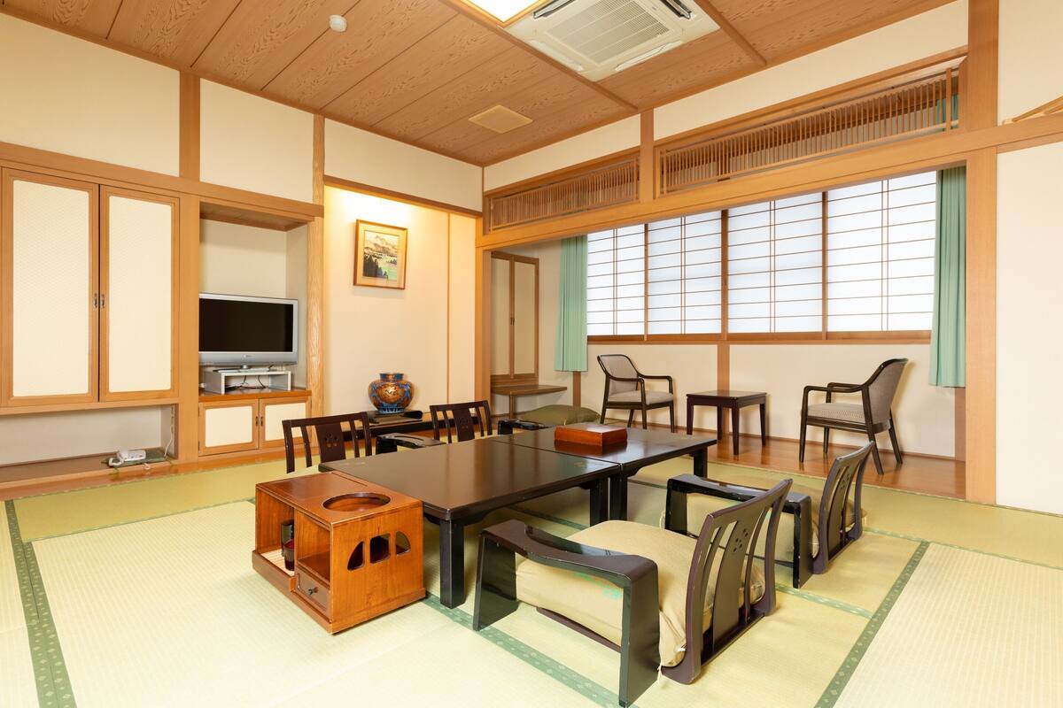 A traditional Japanese-style room with tatami flooring, a low table, and wooden furniture.