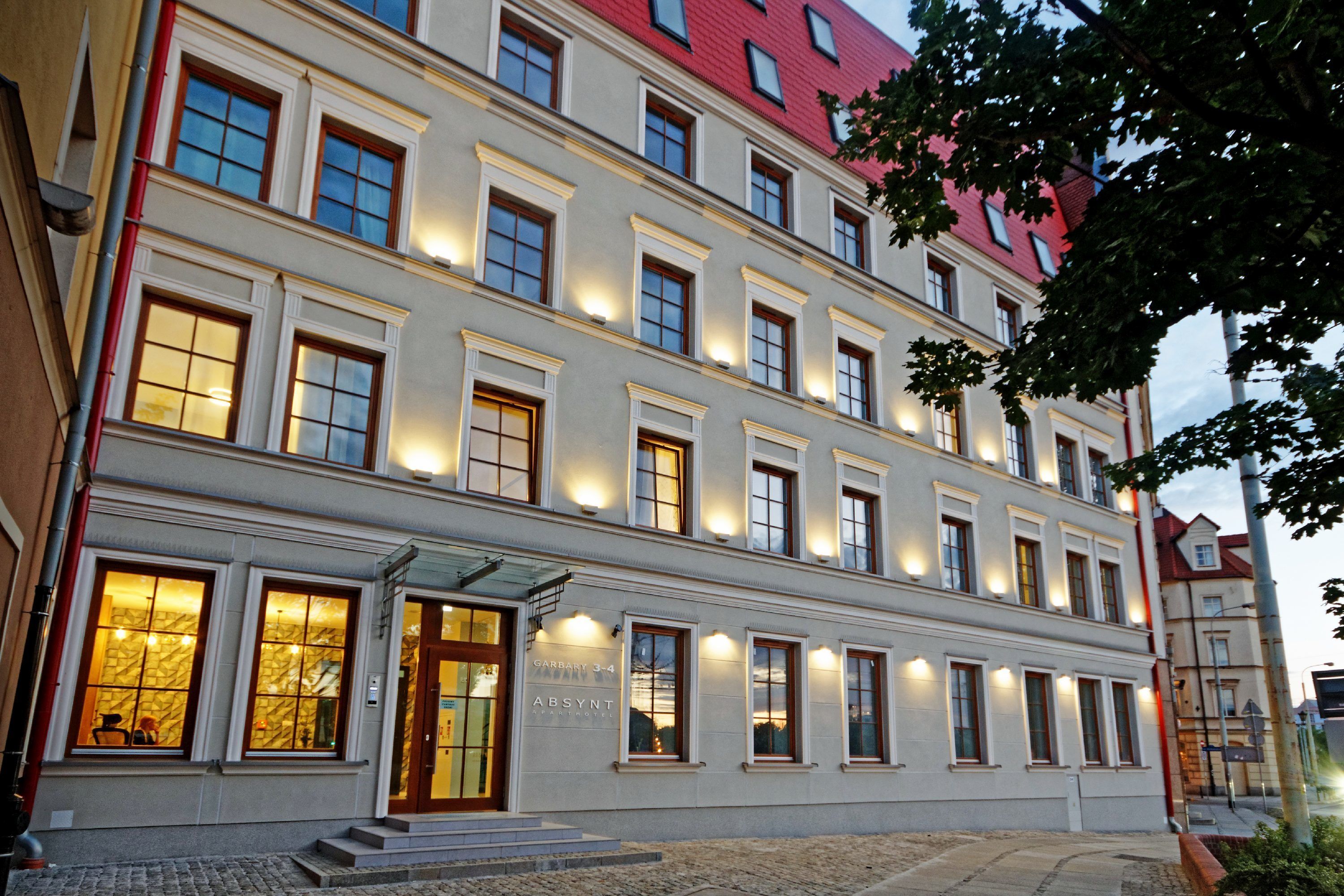 A multi-story building with a classic architectural style, featuring evenly spaced windows and a red roof.
