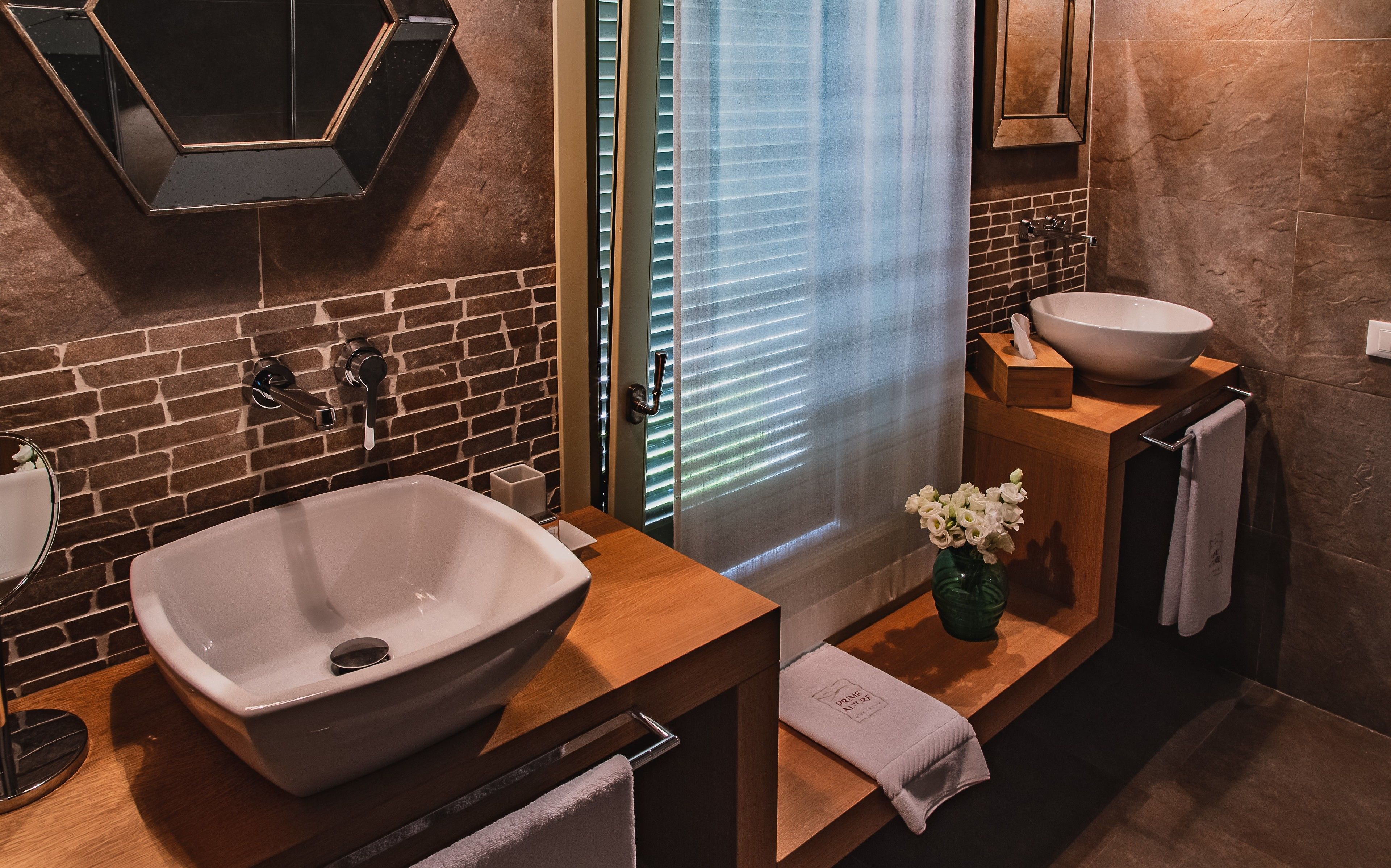 Une salle de bain moderne avec un grand lavabo blanc, un miroir et un meuble-lavabo en bois.